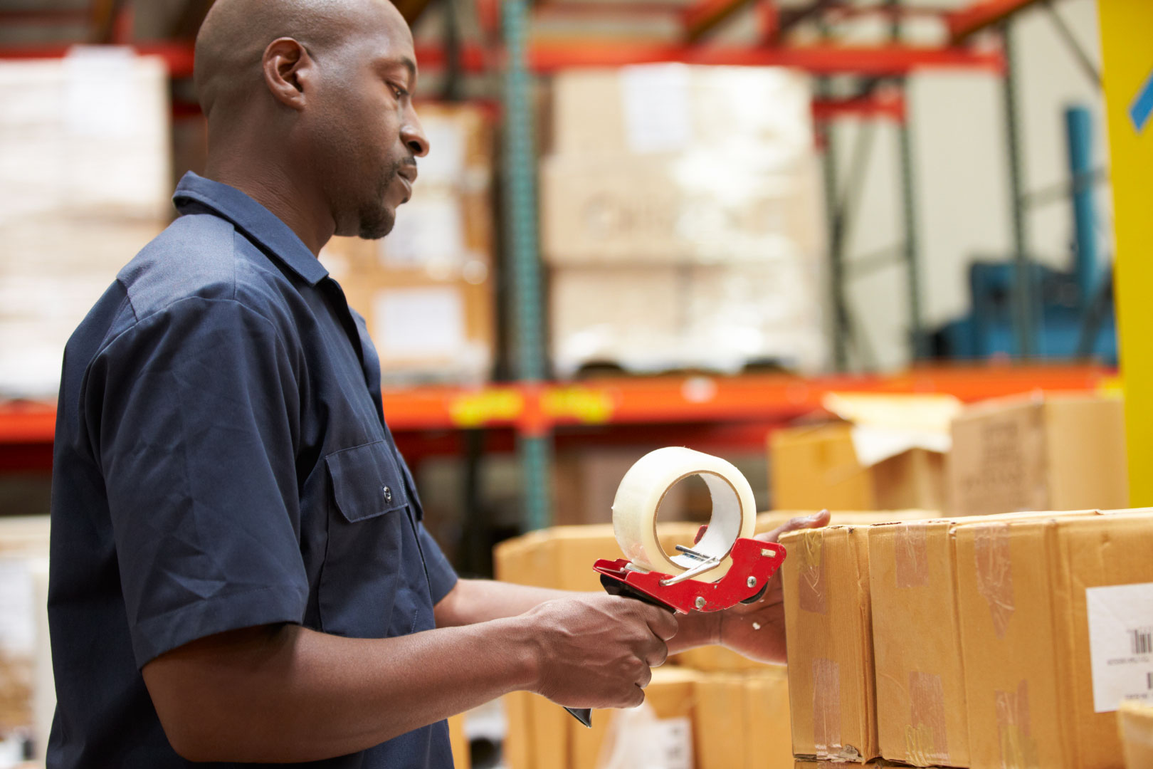 Employé de la logistique scellant le colis